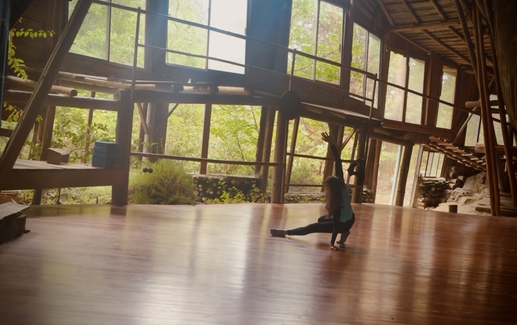 Woman dancing on open studio floor.
