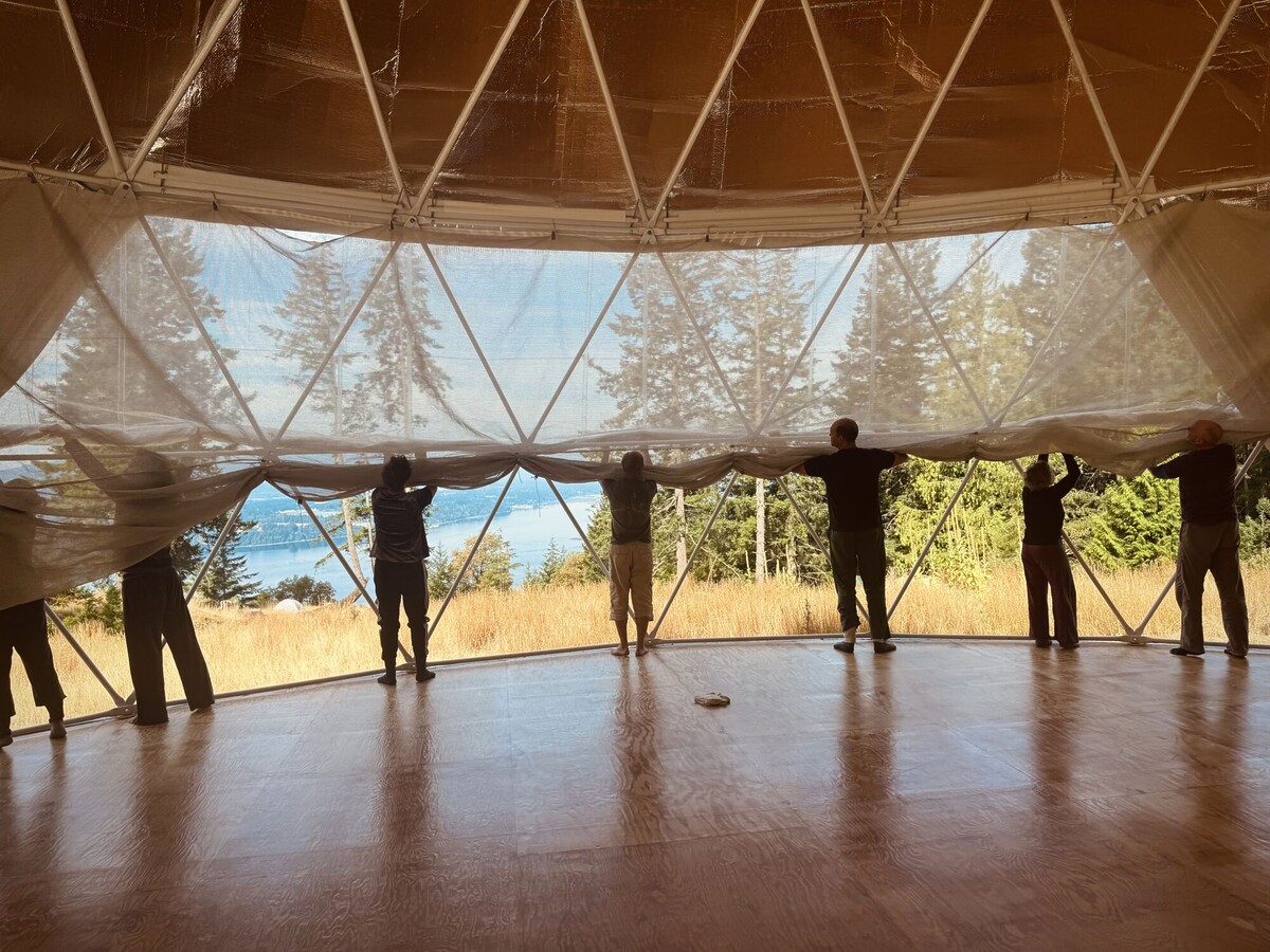 Dancers helping to roll up window cover.